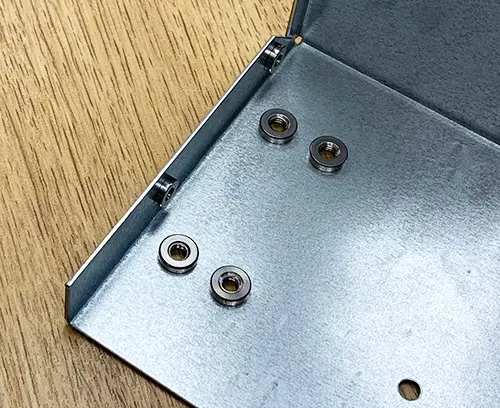 Écrous de fixation M4 (à l'intérieur) montés sur le panneau.